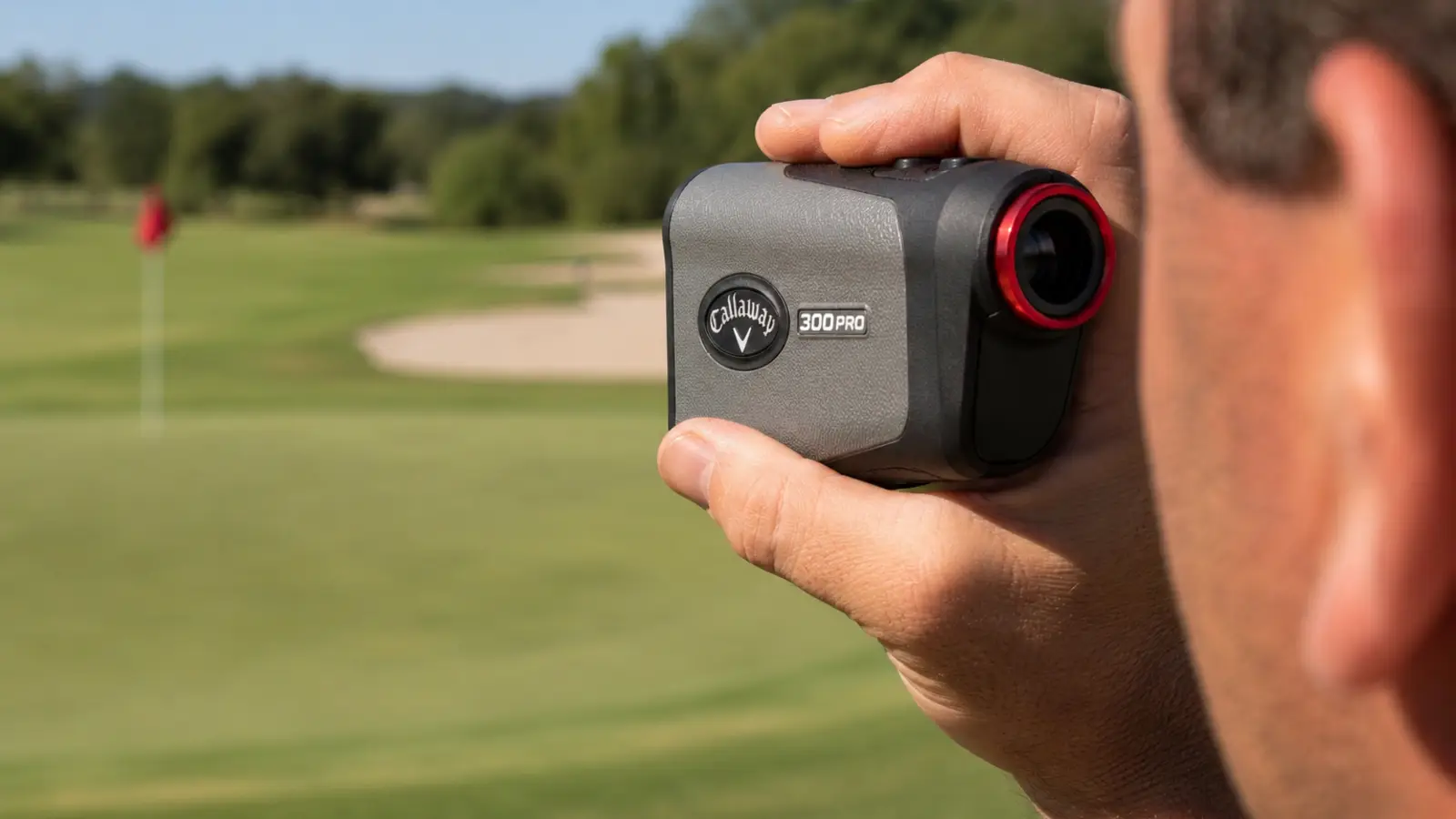 Close-up of a hand holding the Callaway 300 Pro rangefinder with the display showing a yardage reading