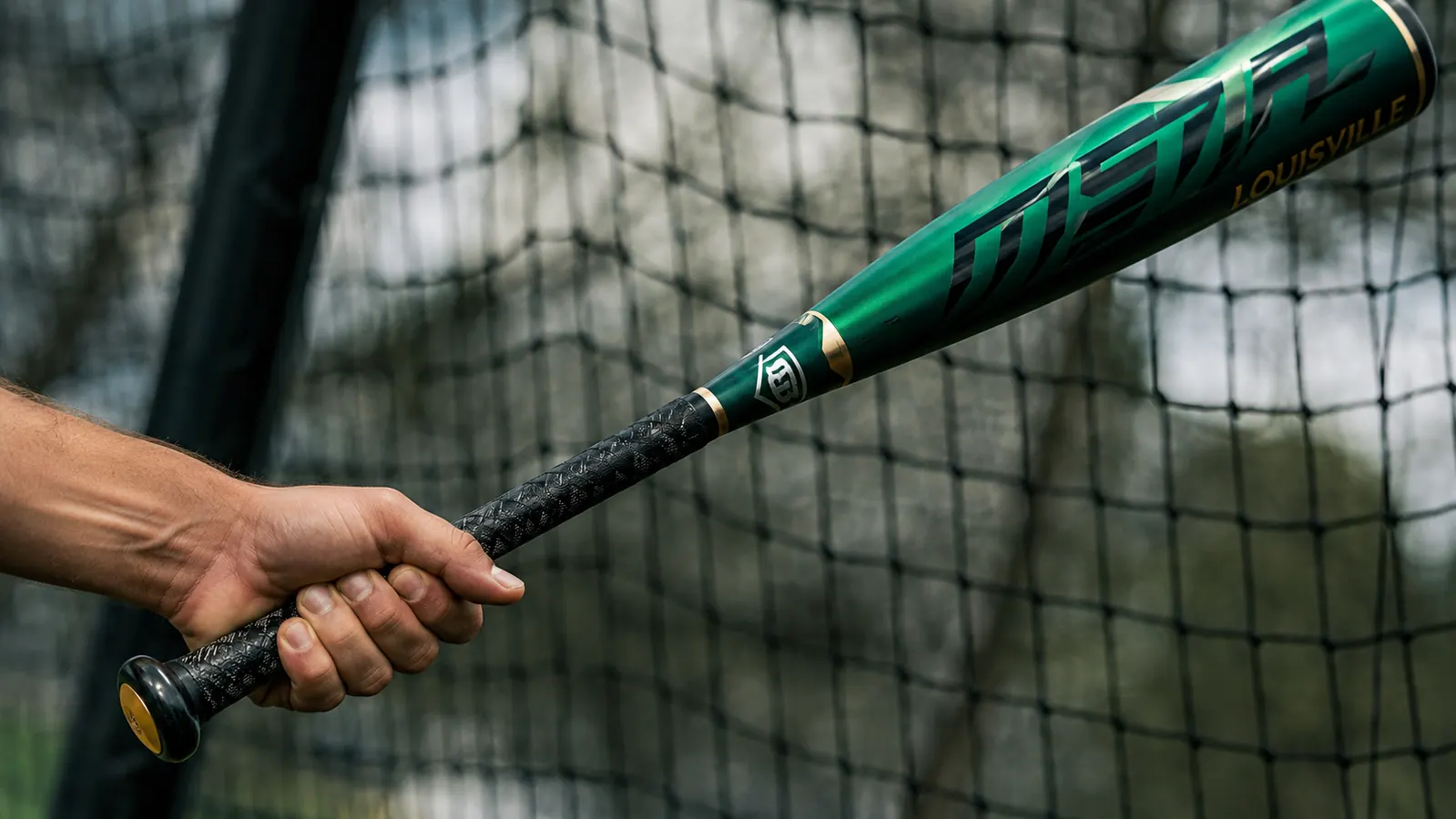 Hand gripping the Louisville Slugger Meta bat handle showing the factory grip texture up close