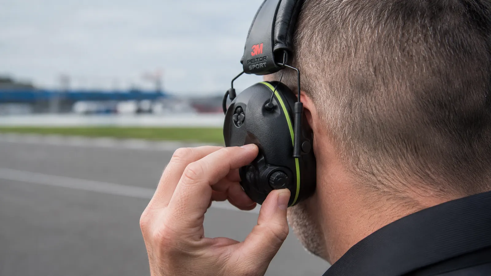 Close-up of a hand adjusting the volume dial on the Peltor Sport Tactical 500 earmuff
